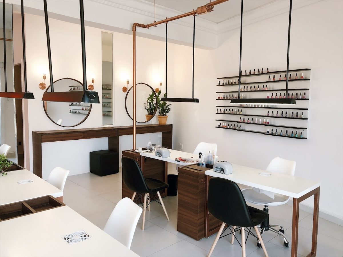 Interior do estúdio Gringas Nails: bancadas brancas, cadeiras e espelhos redondos